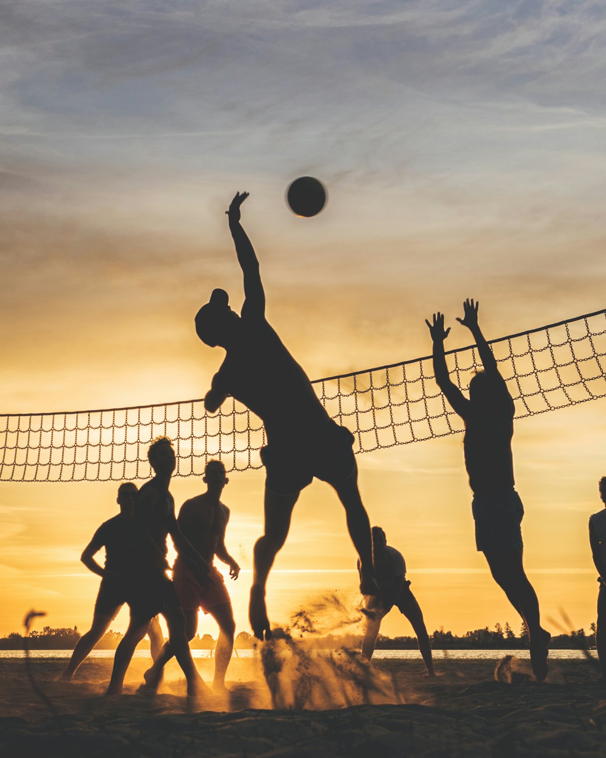 Giocatori in scambio su un campo da beach volley nell'ora dorata.