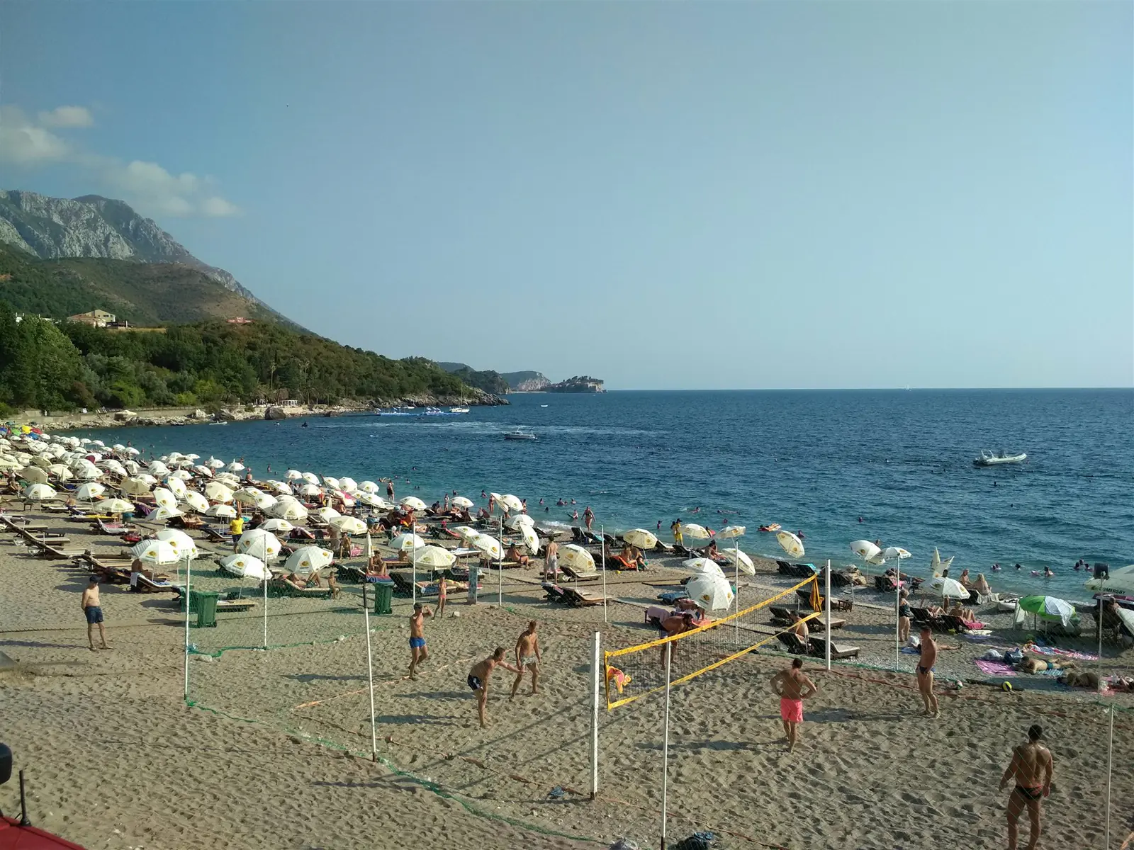 Siatkarze plażowi na ruchliwej plaży nad morzem.