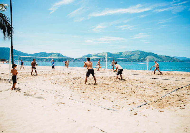 Giocatori di un club di beach volley si scaldano insieme vicino alle reti.